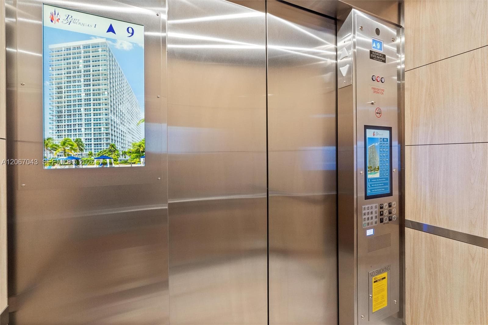 Elevator featuring brushed stainless steel doors, integrated digital touchscreen control panel, and wood-finish wall paneling