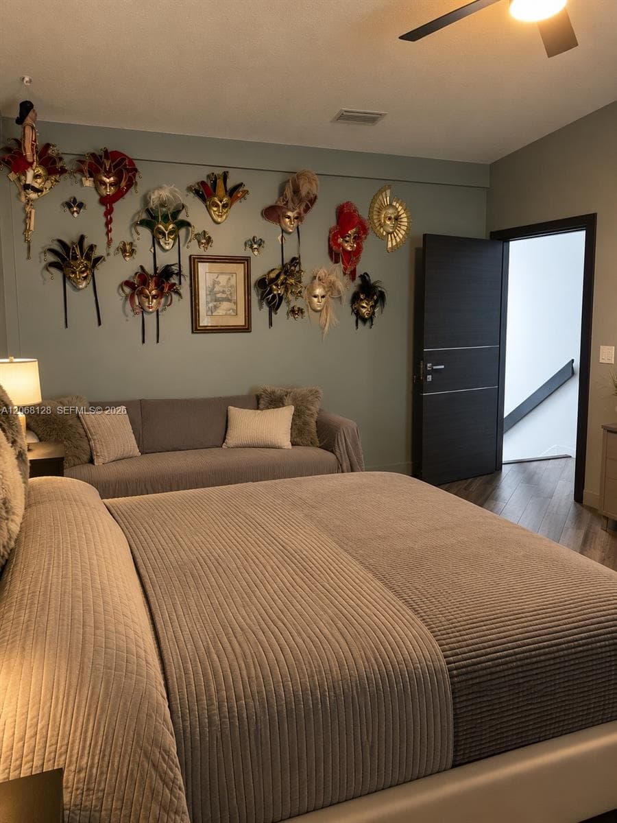 Wood-finish flooring, dark-toned interior door with horizontal detailing, and a ceiling-mounted light fixture