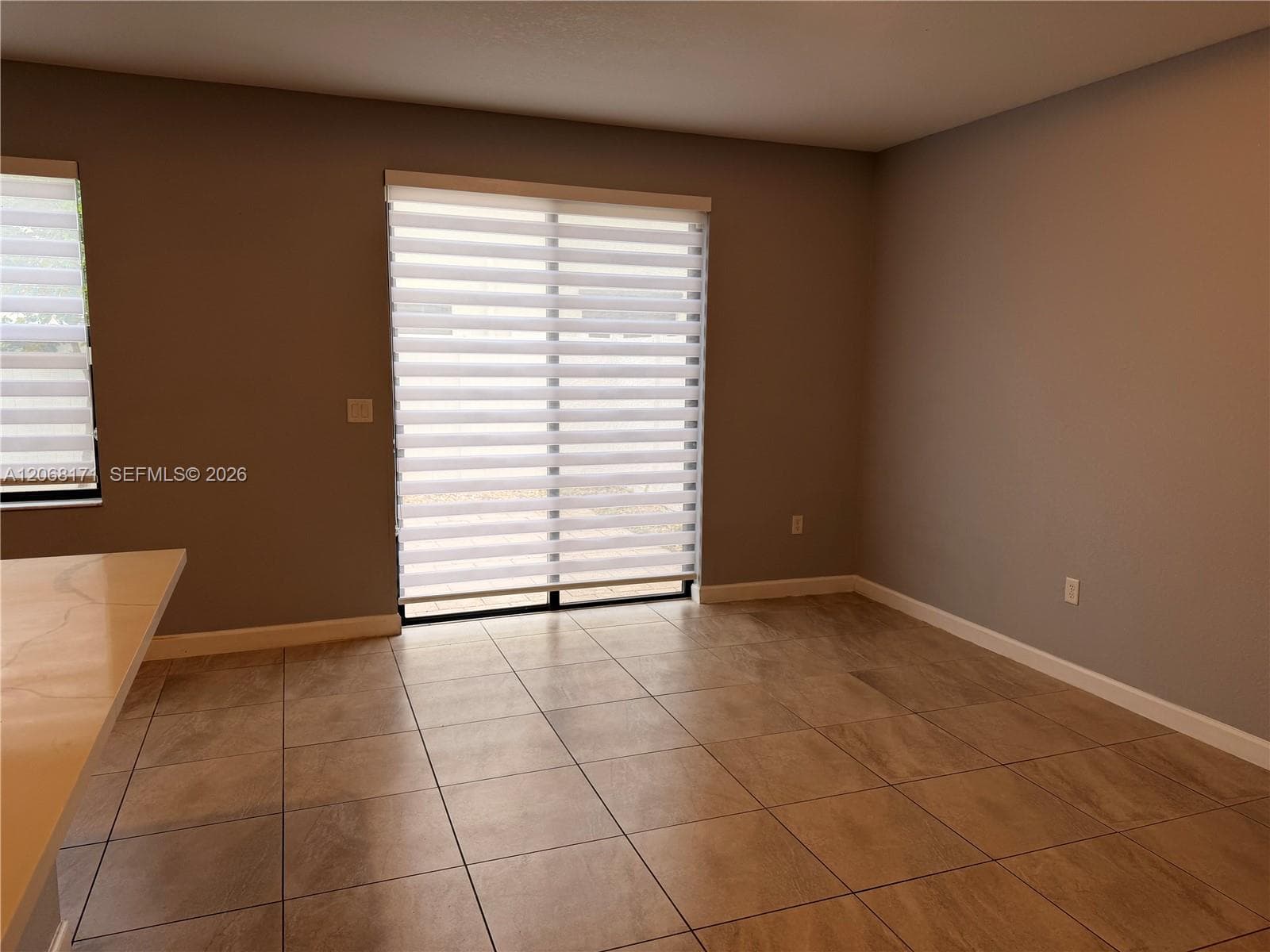 Ceramic tile flooring, sliding glass door, and neutral wall tones