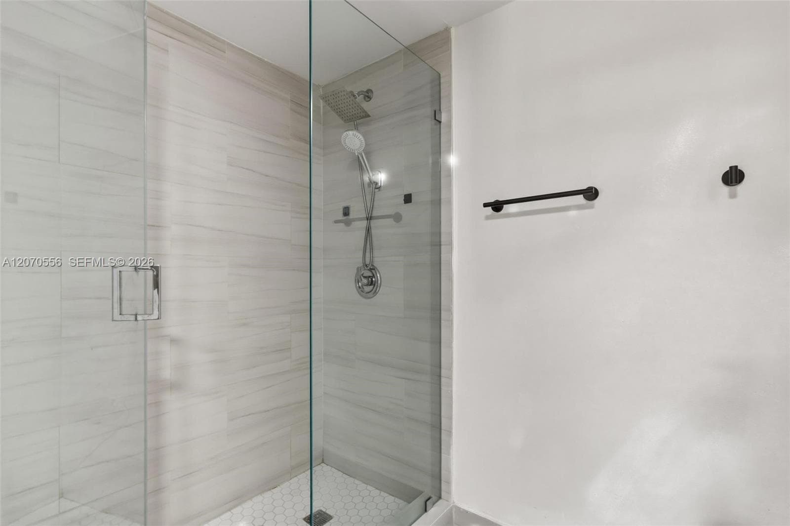 A spacious walk-in shower with a sleek glass enclosure, modern finishes, and an oversized rain-style showerhead.
