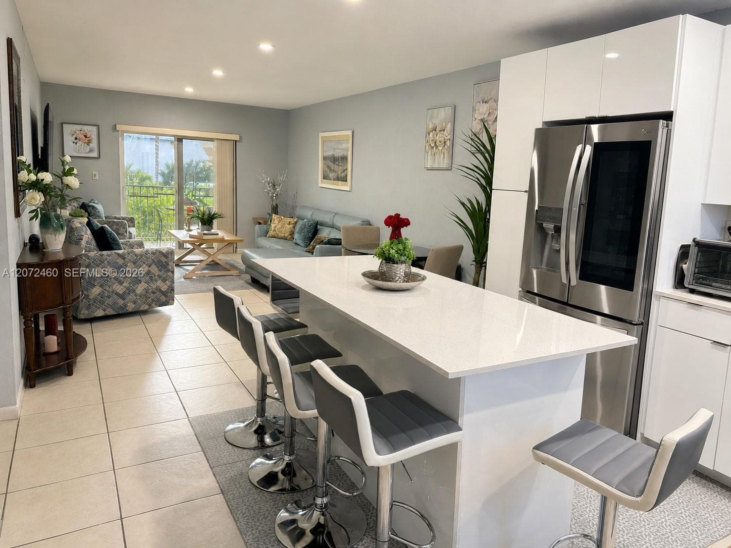 Modern Open-Concept Kitchen & Living AreaBright open-concept layout featuring a large kitchen island, modern cabinetry, stainless-steel appliances, and direct access to the private balcony.