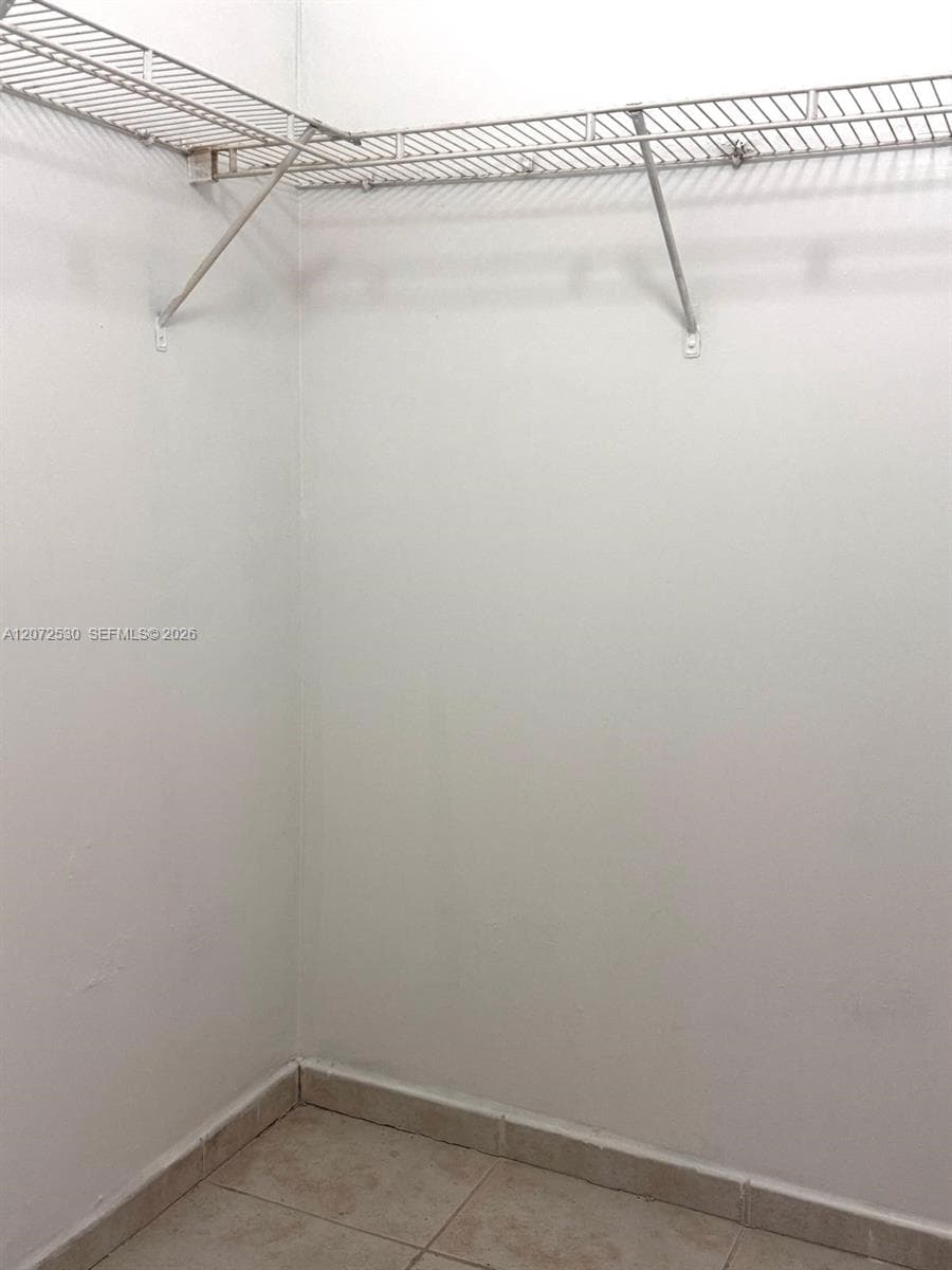 Storage space featuring wire shelving and ceramic tile flooring