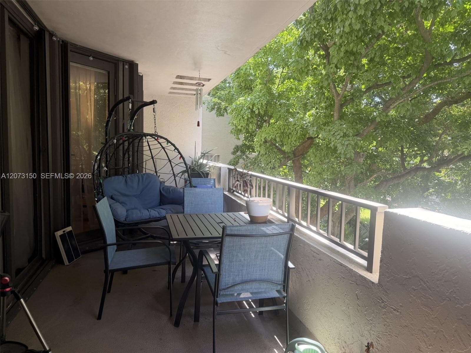 Covered balcony featuring concrete flooring, a solid masonry partial wall, and a metal railing