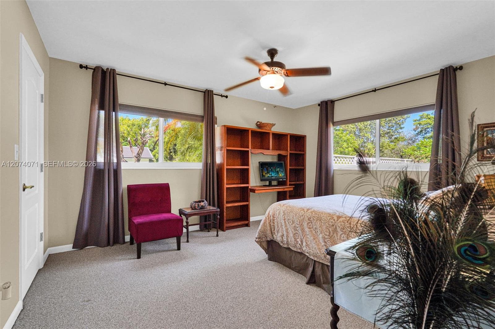 Spacious bedroom with large windows and backyard views.