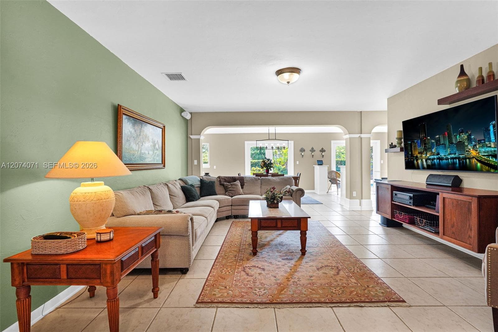 Spacious living room with natural light, tile floors, and open layout ideal for entertaining.
