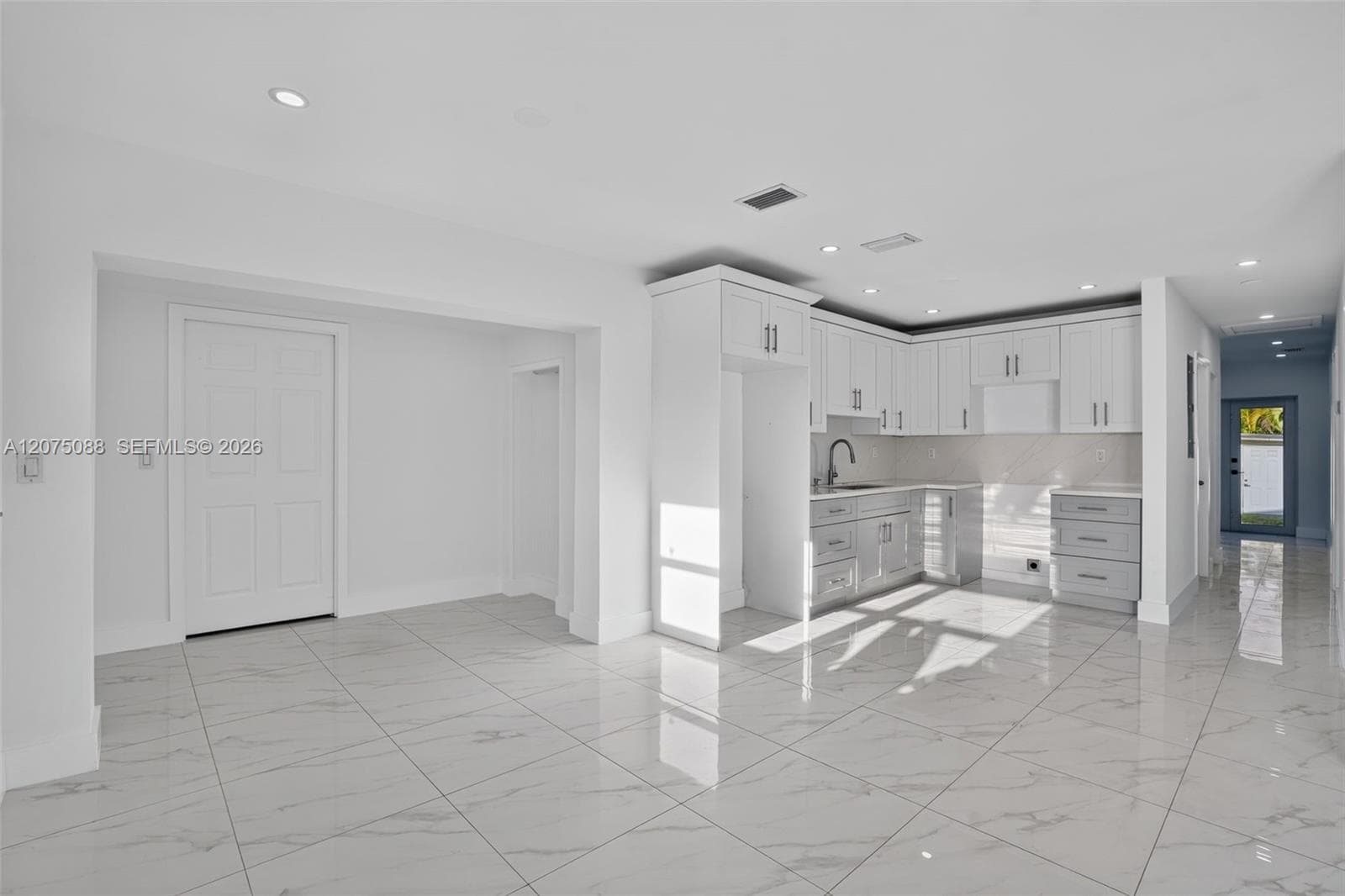 Kitchen featuring white shaker-style cabinetry, stone-finish countertops, tile flooring, recessed lighting, and a gooseneck faucet
