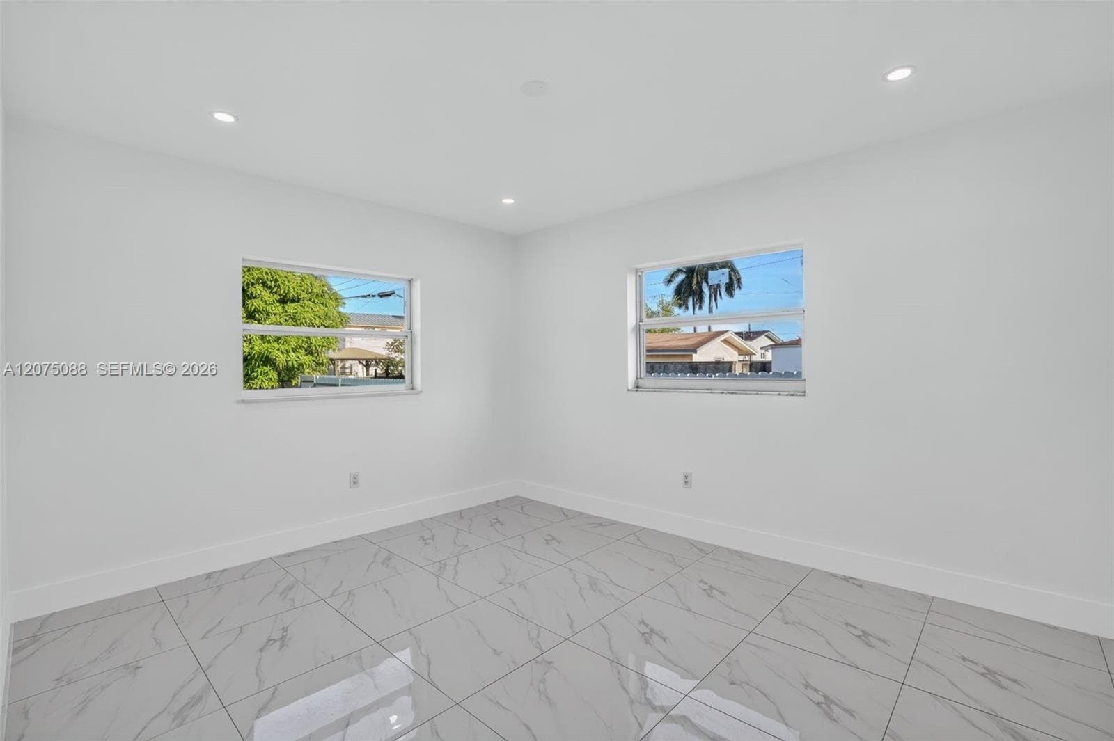 Room featuring large-format tile flooring with a neutral pattern, recessed lighting, and dual windows