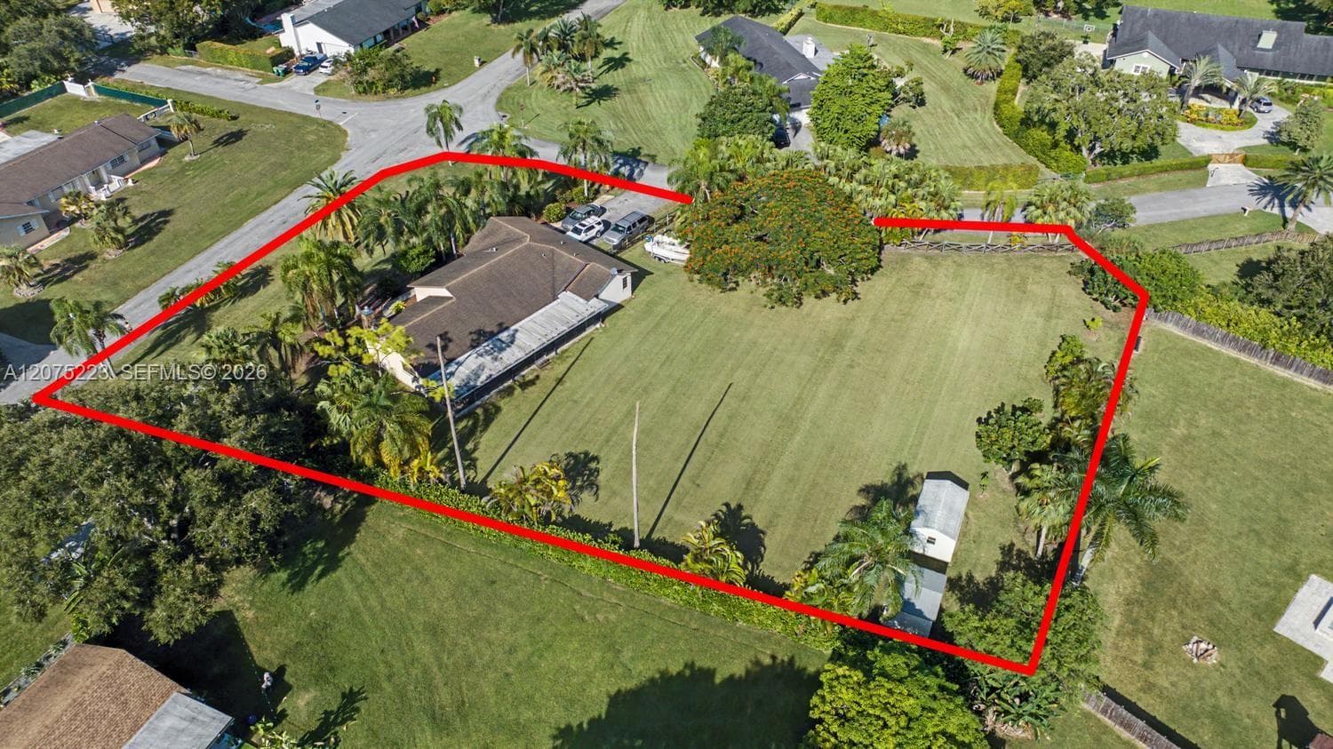 Aerial view highlights the impressive property size, expansive backyard and established tropical landscaping.
