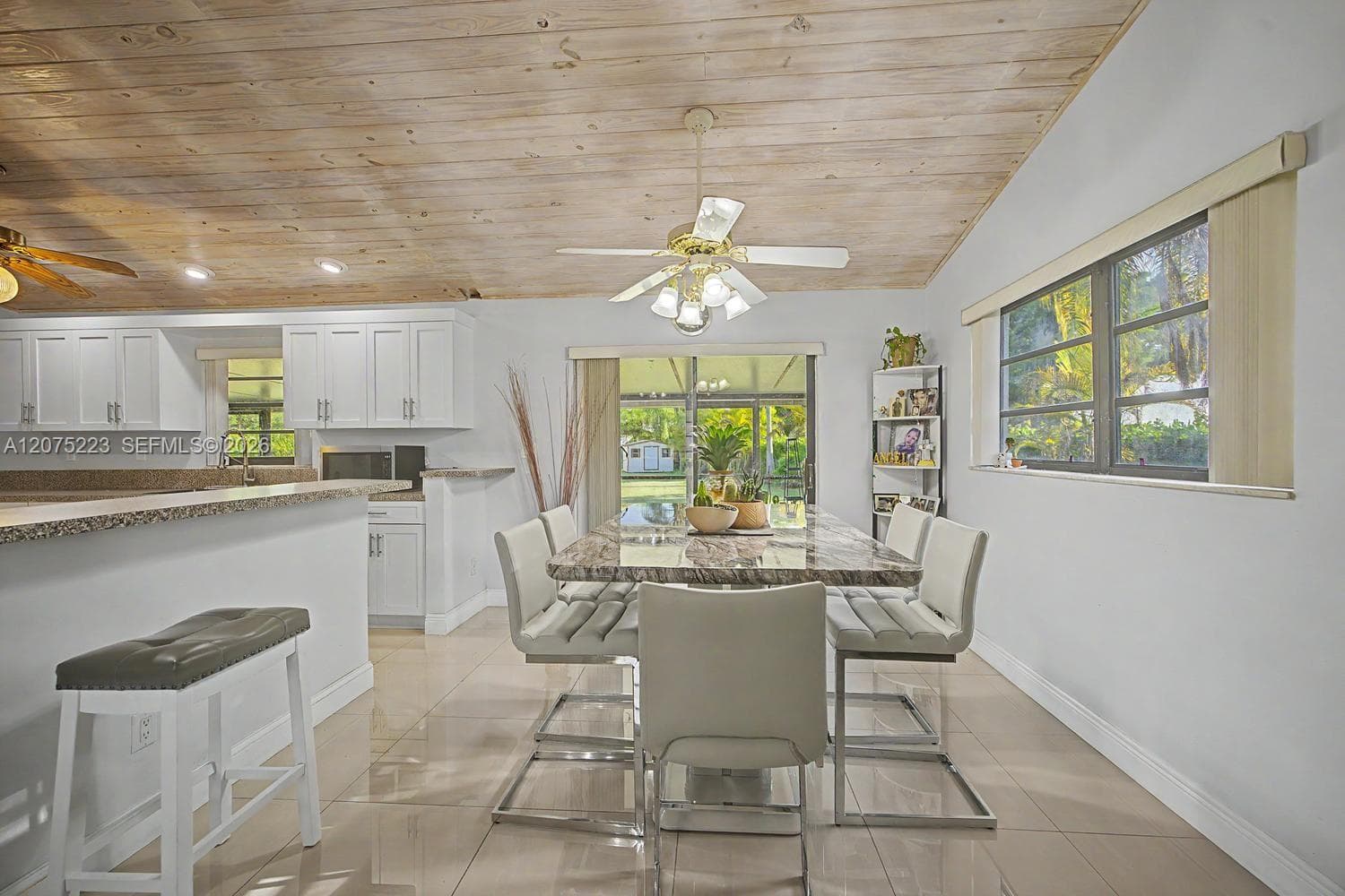 Dining area conveniently positioned between the kitchen and screened outdoor living space.