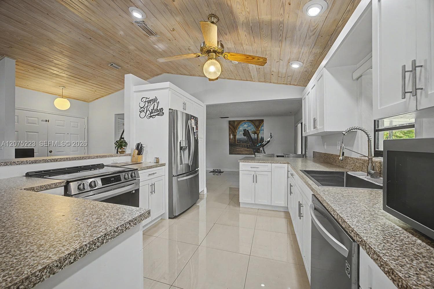 Updated kitchen features white cabinetry, granite countertops, stainless steel appliances and ample workspace.