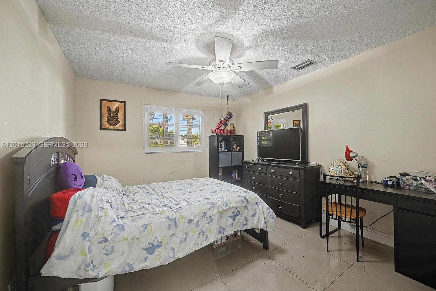 Secondary bedroom 2 featuring tile flooring, ceiling fan and natural light