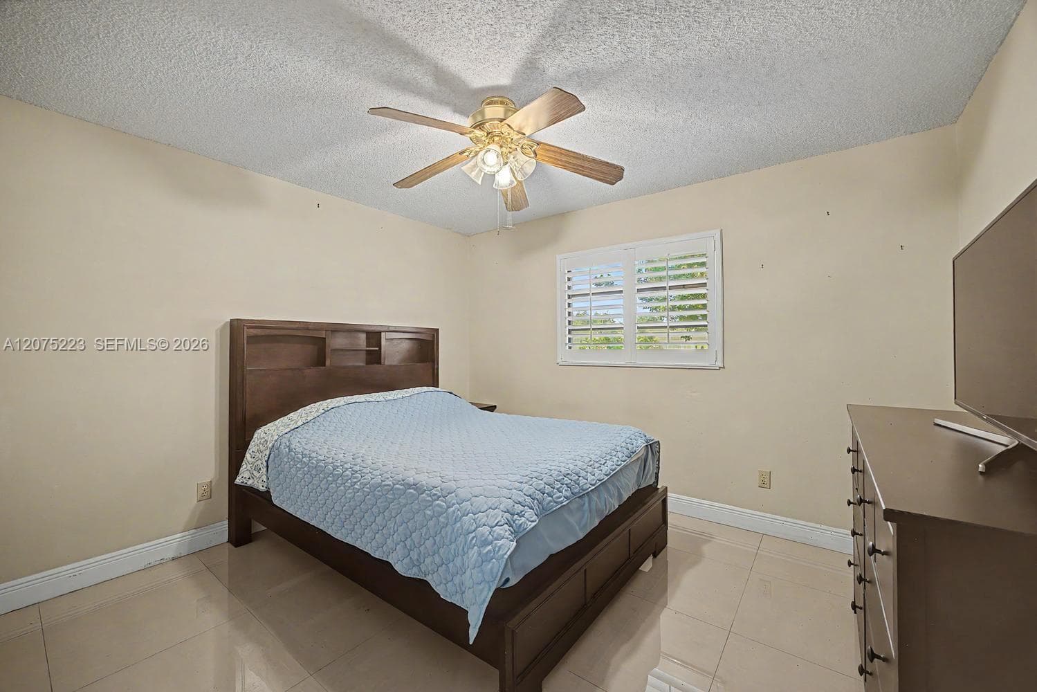 Comfortable secondary bedroom 3 with tile flooring, ceiling fan and natural light.