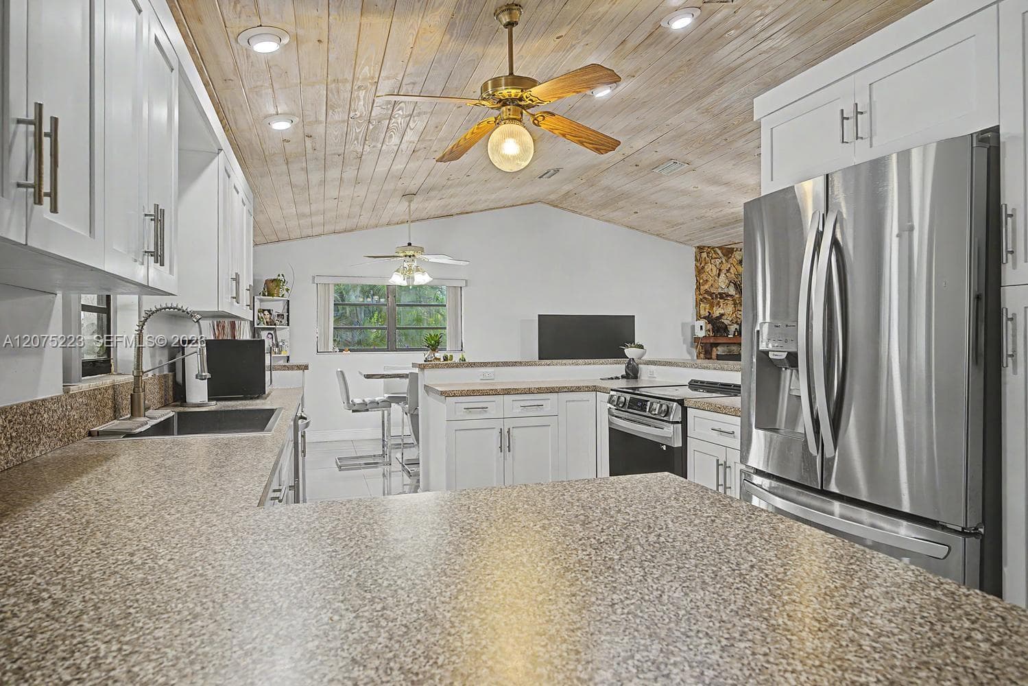 Spacious kitchen with abundant cabinetry and counter space, stainless steel appliances and breakfast-bar seating.