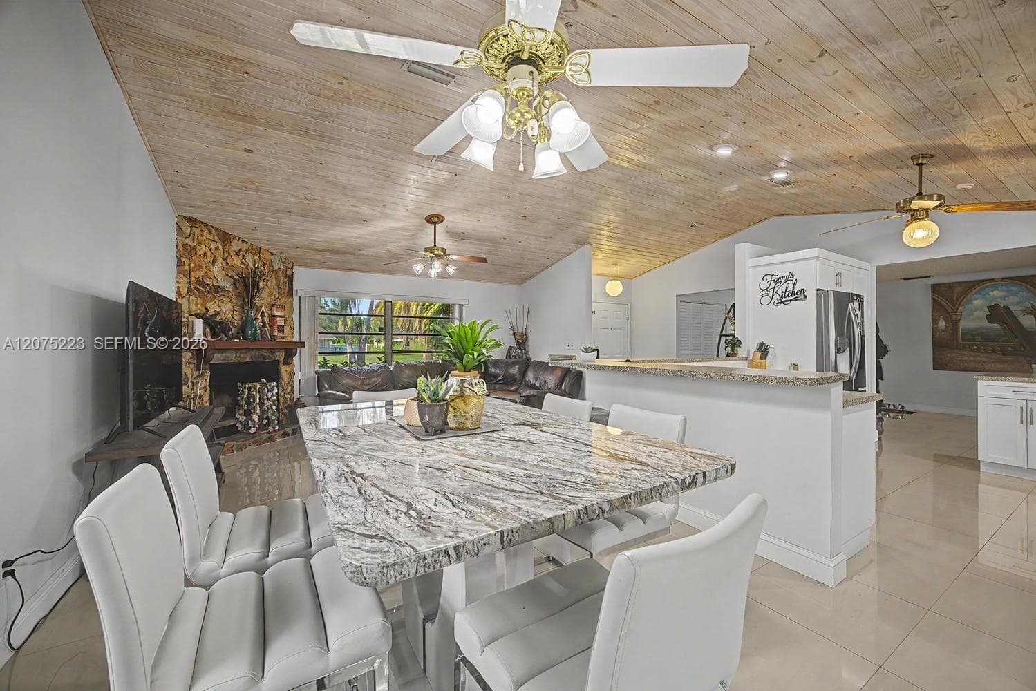 Dining and living areas flow together beneath vaulted wood-plank ceilings, creating an open and inviting atmosphere.
