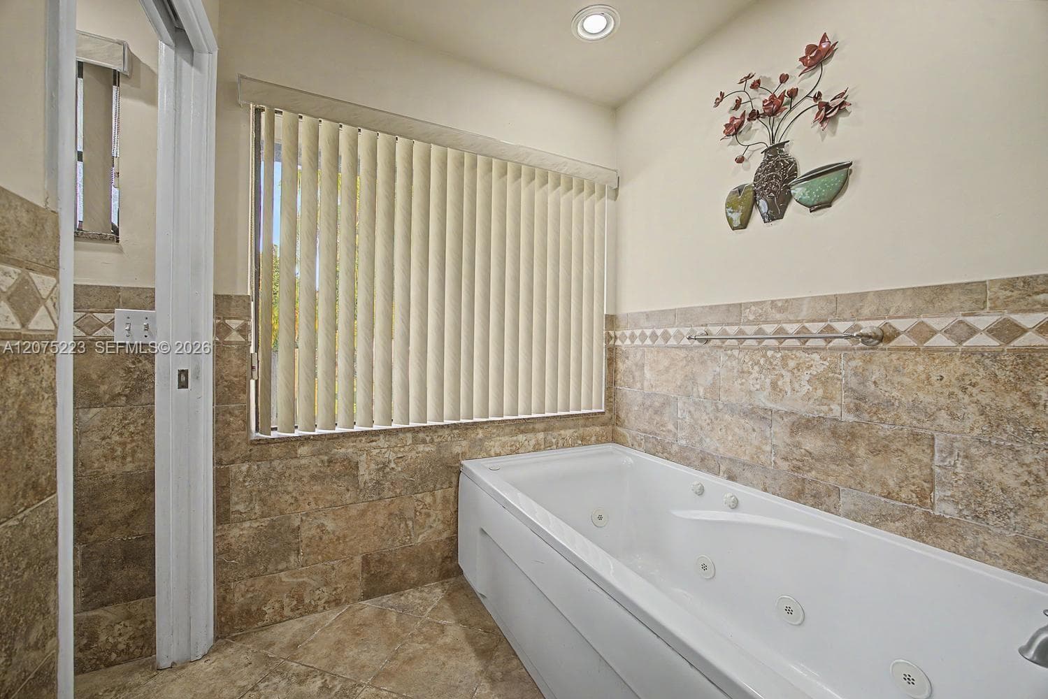 Relax and unwind in the jetted soaking tub, surrounded by tile and natural light.
