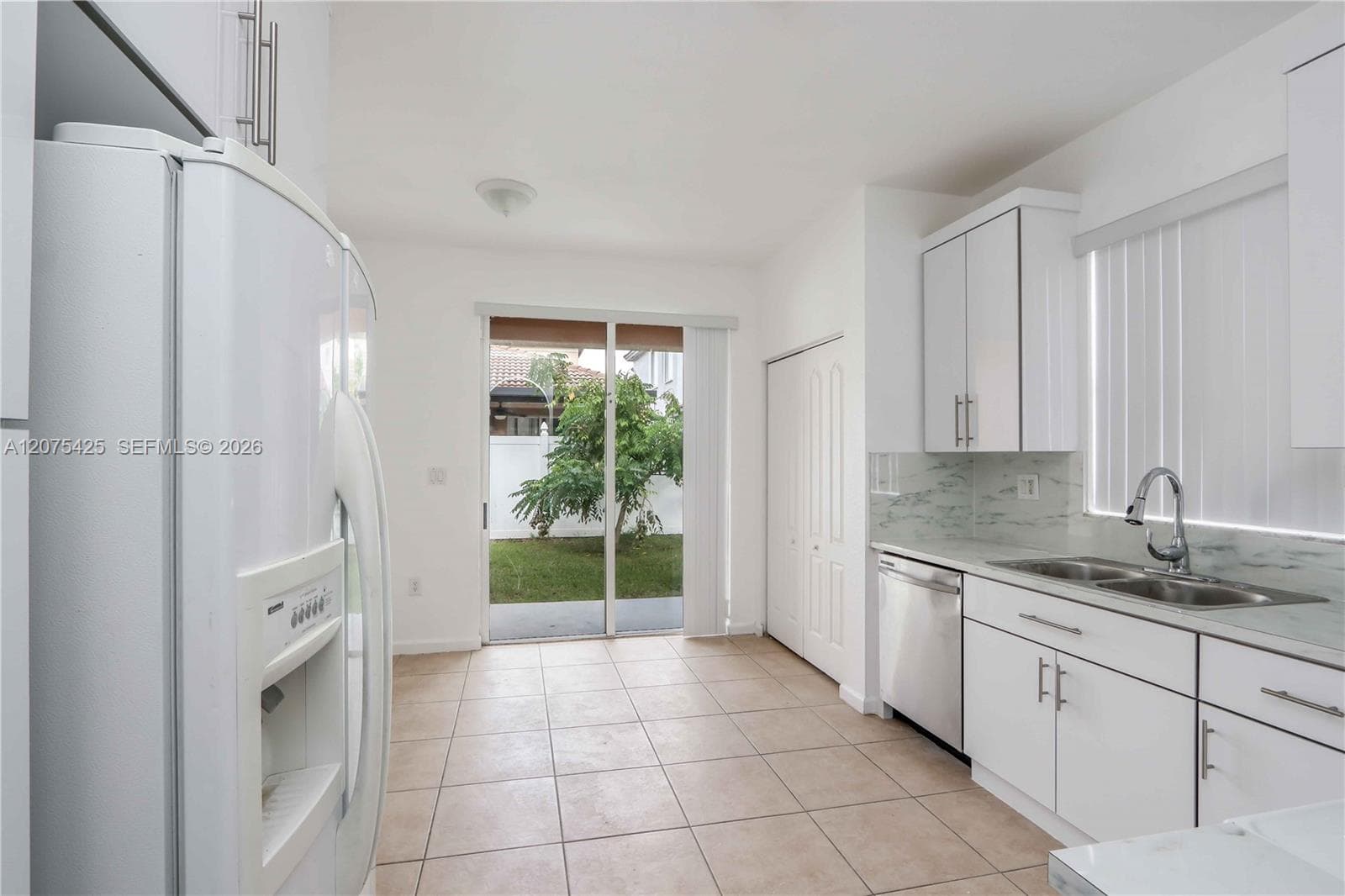 Modern kitchen featuring white cabinetry and appliances.