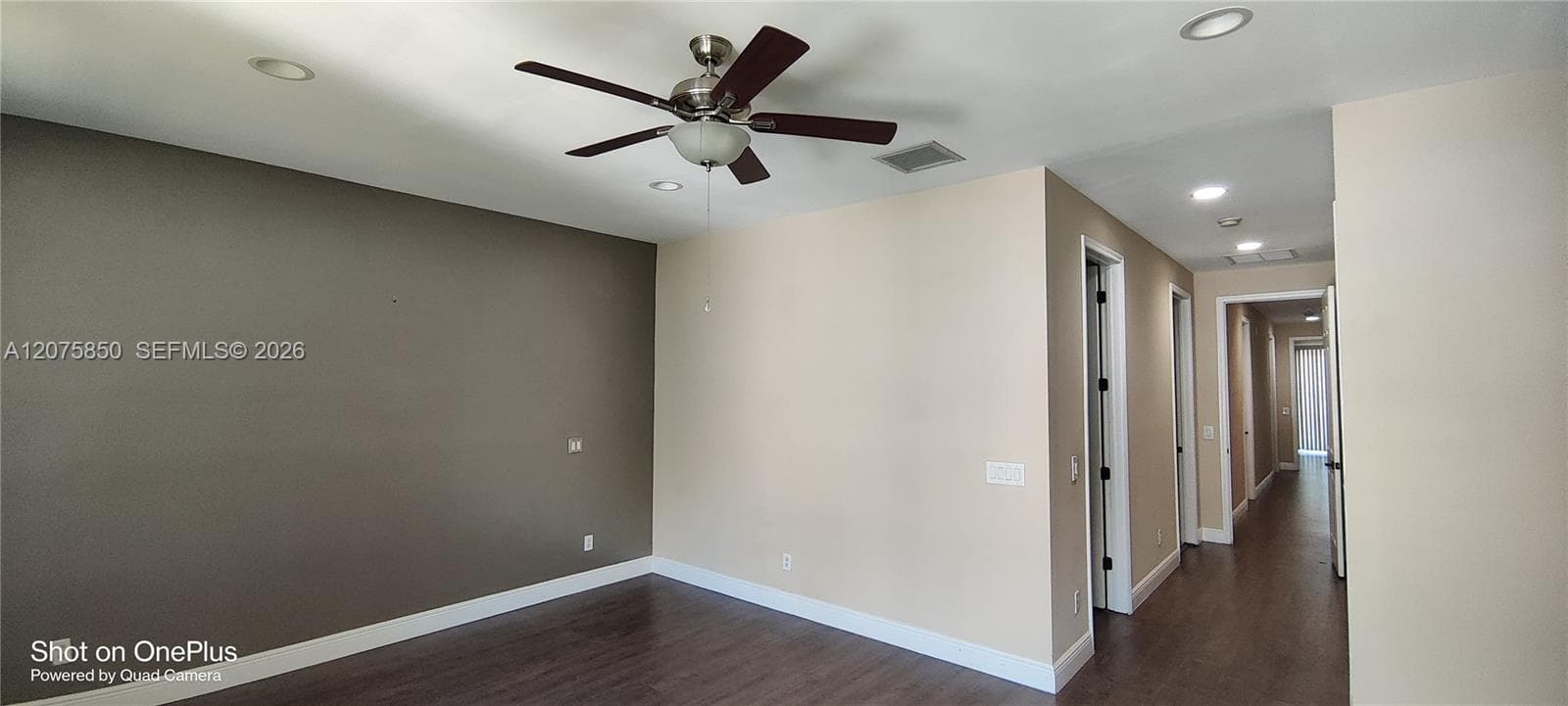 Interior space featuring wood-finish flooring, a multi-blade ceiling fan with integrated lighting, and recessed ceiling illumination