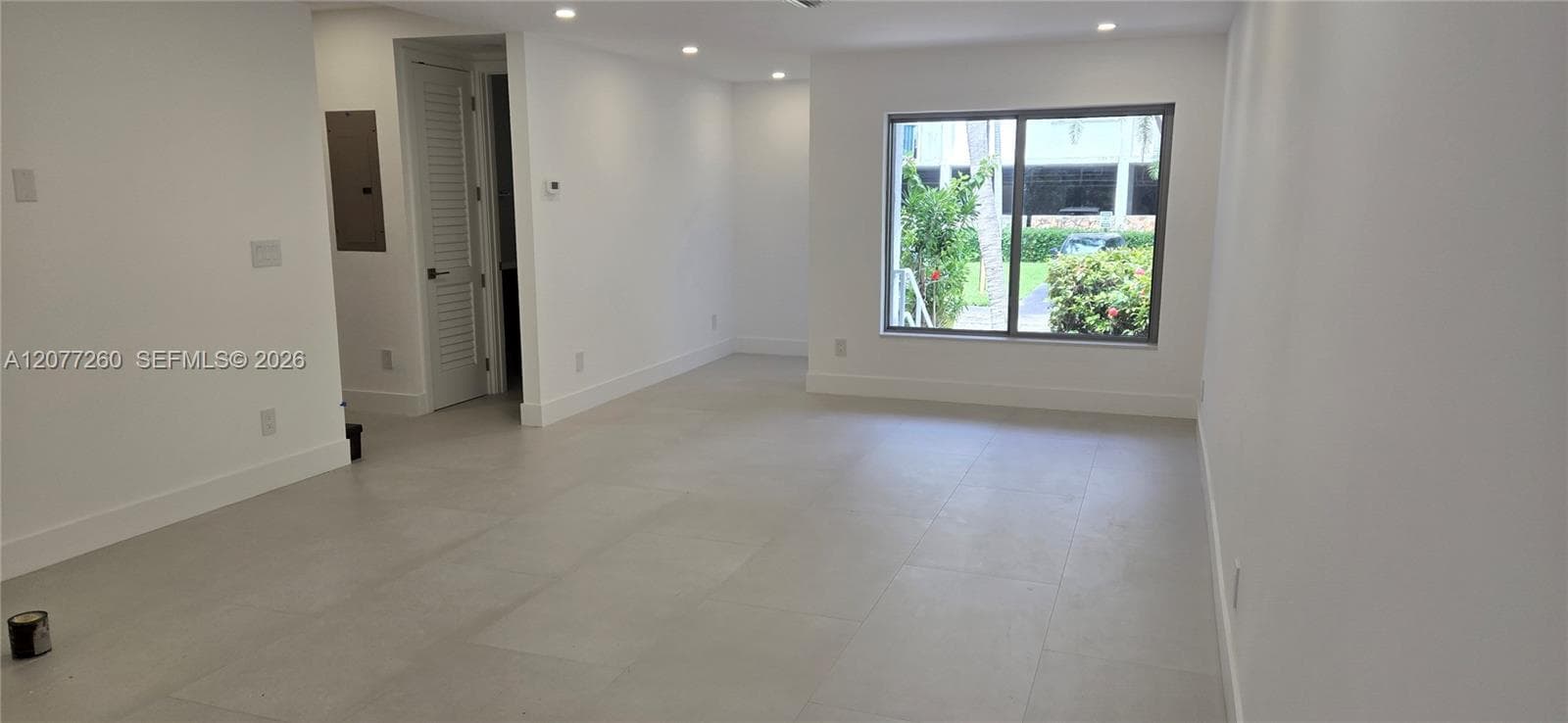 Interior view from living area to front entry. Full bathroom on the main floor. IMPACT windows and doors throughout.