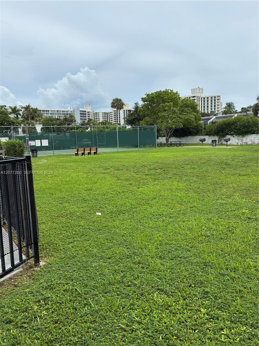 Open grassy area ideal for play area and directly next to the tennis court, pool and grills.