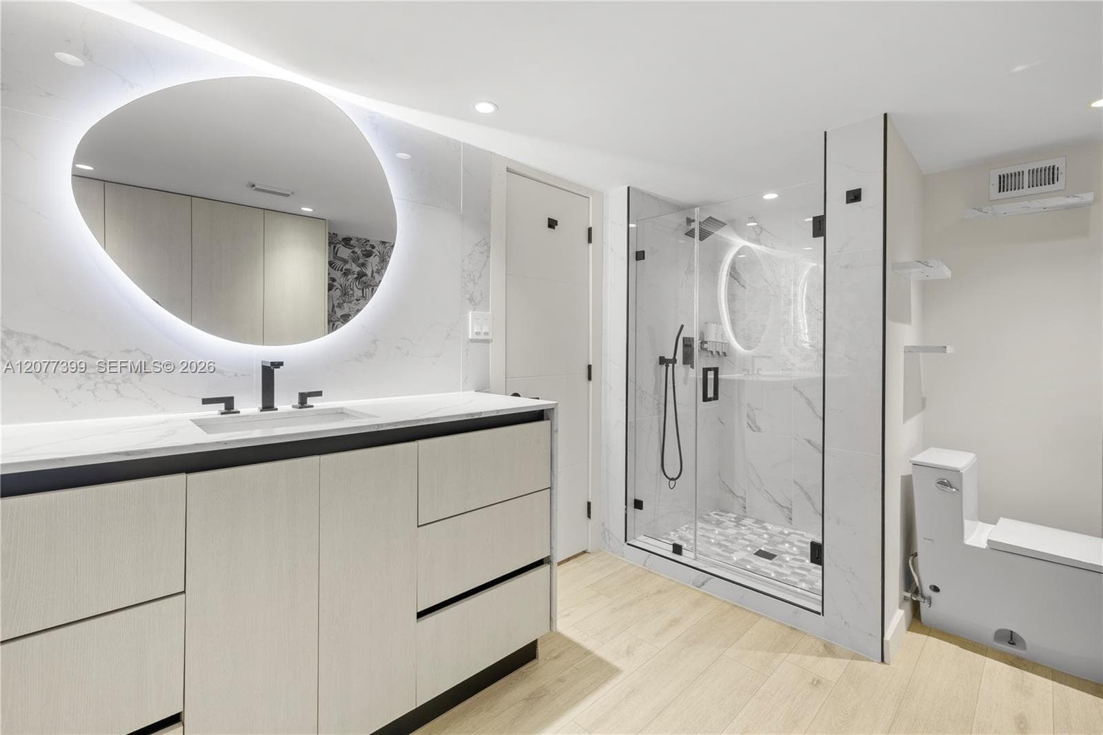 Modern vanity with stone-finish countertop, integrated sink, and back-lit circular mirror