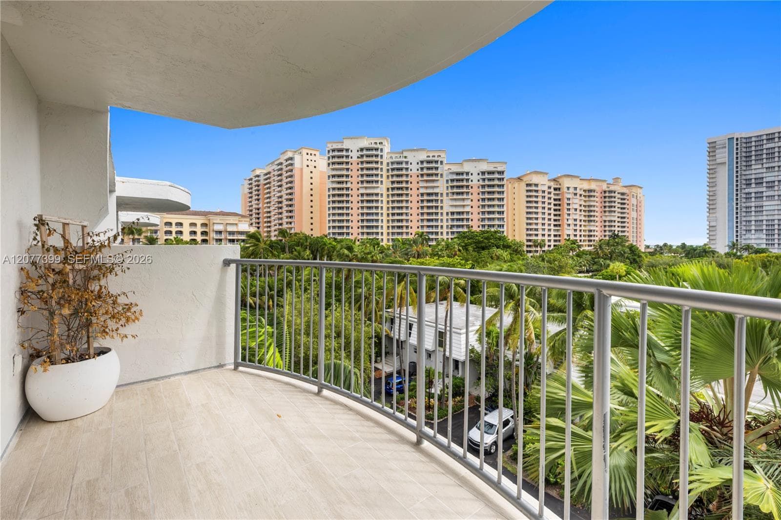 Covered balcony featuring wood-finish tile flooring and metal railings