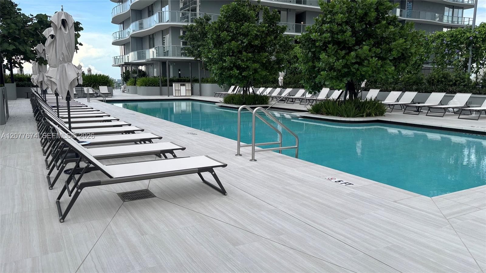 Resort Pool Surrounded by Lush Landscaping and Loungers