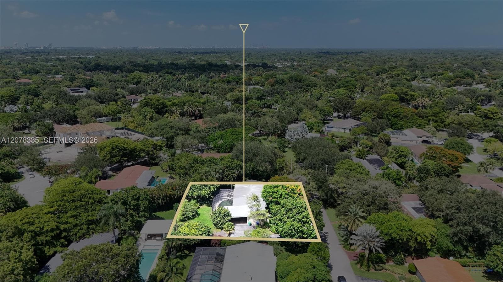 Drone view showcasing the home's layout, spacious lot boundaries, and surrounding lush greenery.