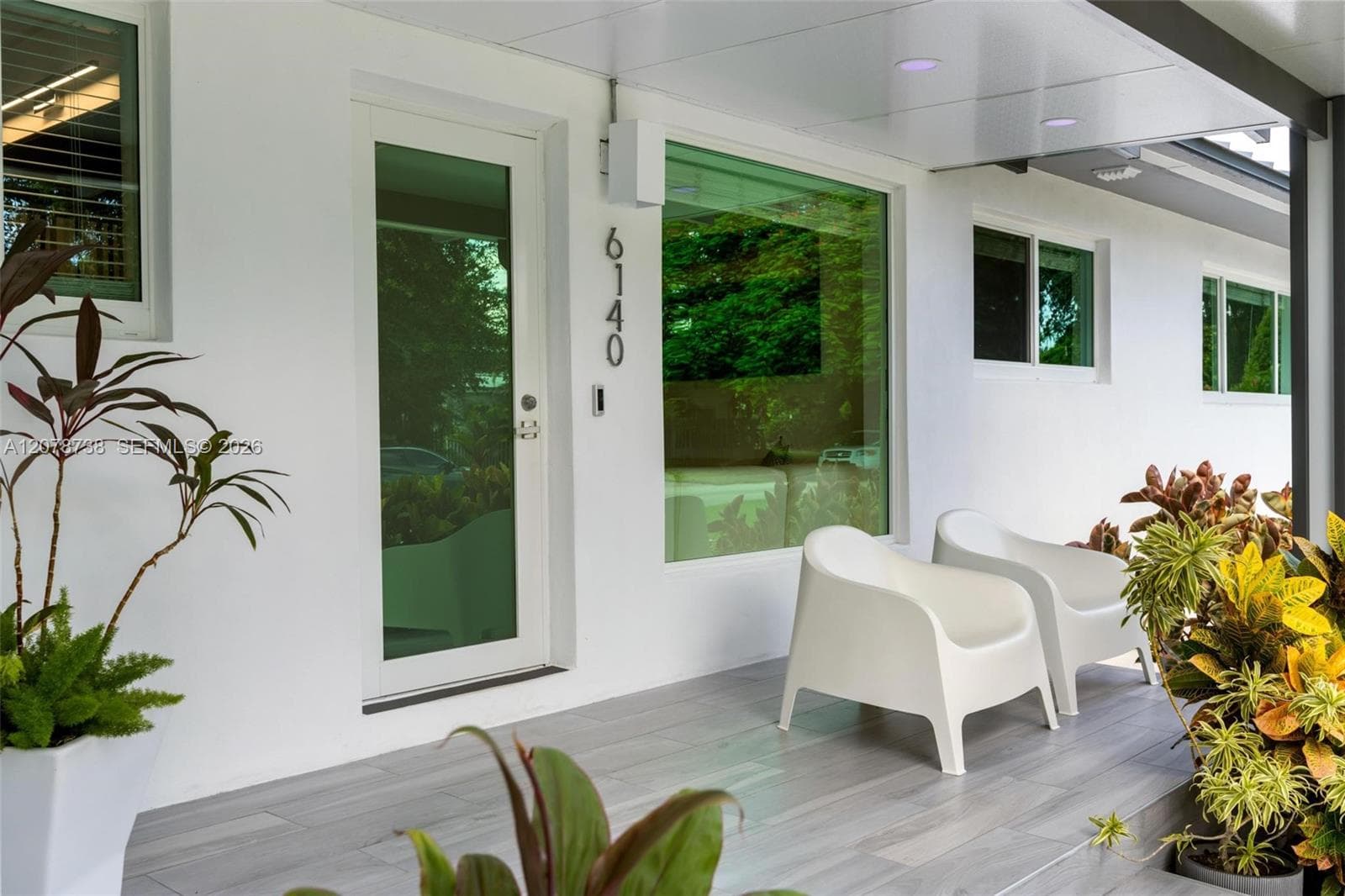 Set beneath mature trees and tropical landscaping, this South Miami home immediately feels private, polished, and welcoming.