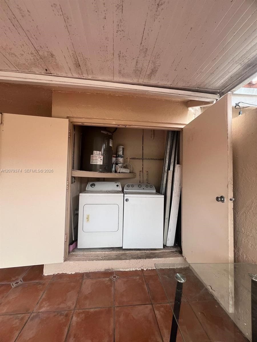 Utility closet featuring double-door access, integrated shelving, and dedicated hookups for laundry appliances