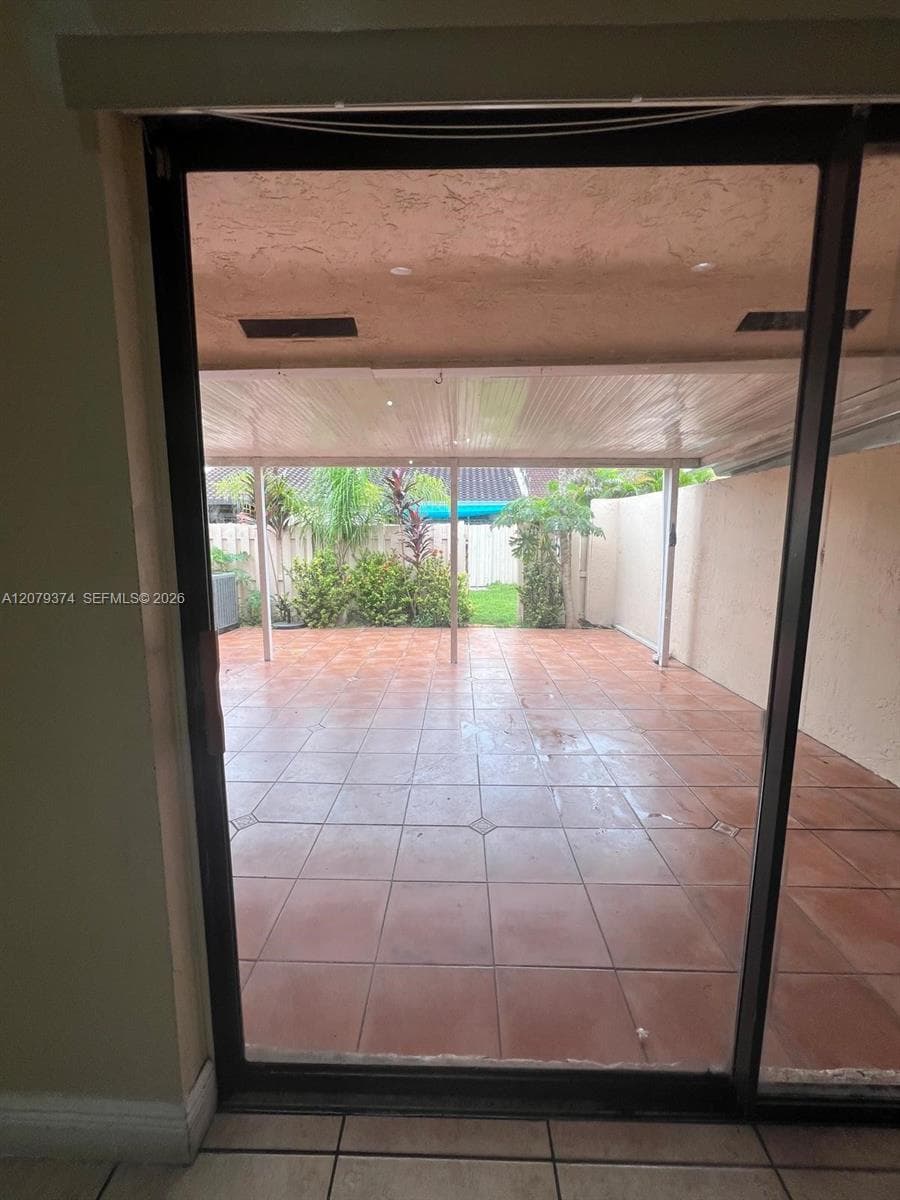 Covered patio featuring ceramic tile flooring, recessed lighting, and a fenced exterior area