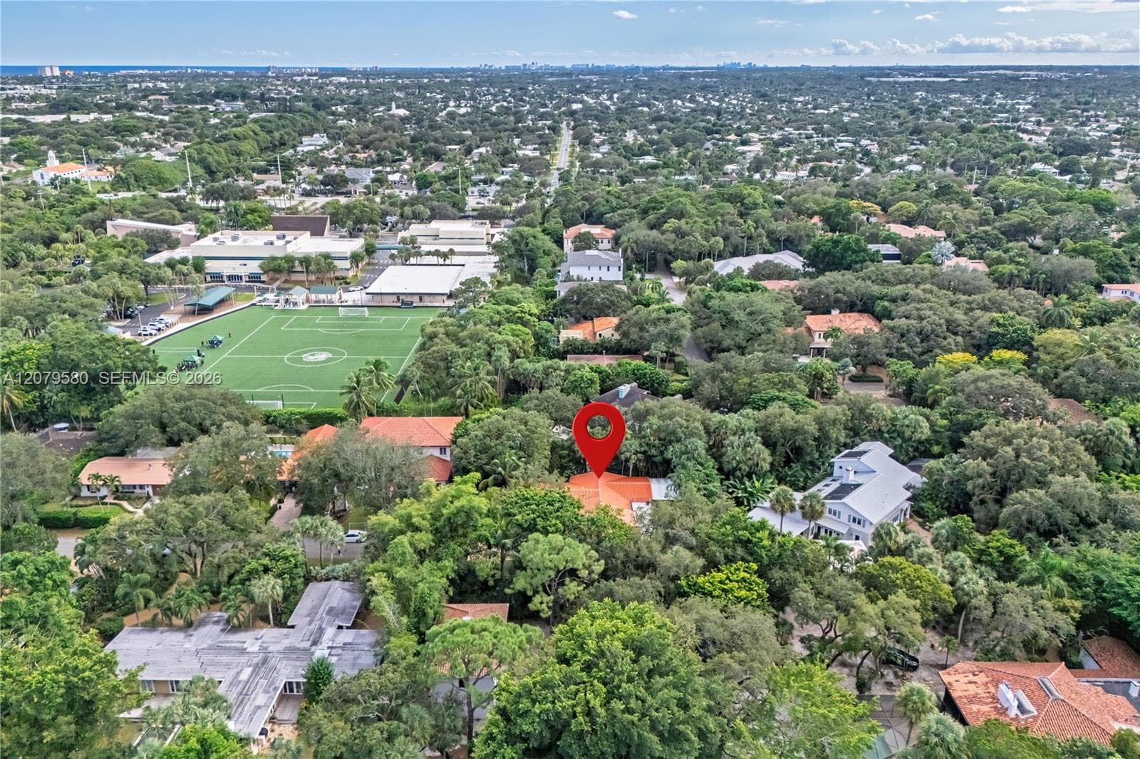 Aerial perspective featuring a residential lot characterized by mature tree canopy and surrounding tropical landscaping