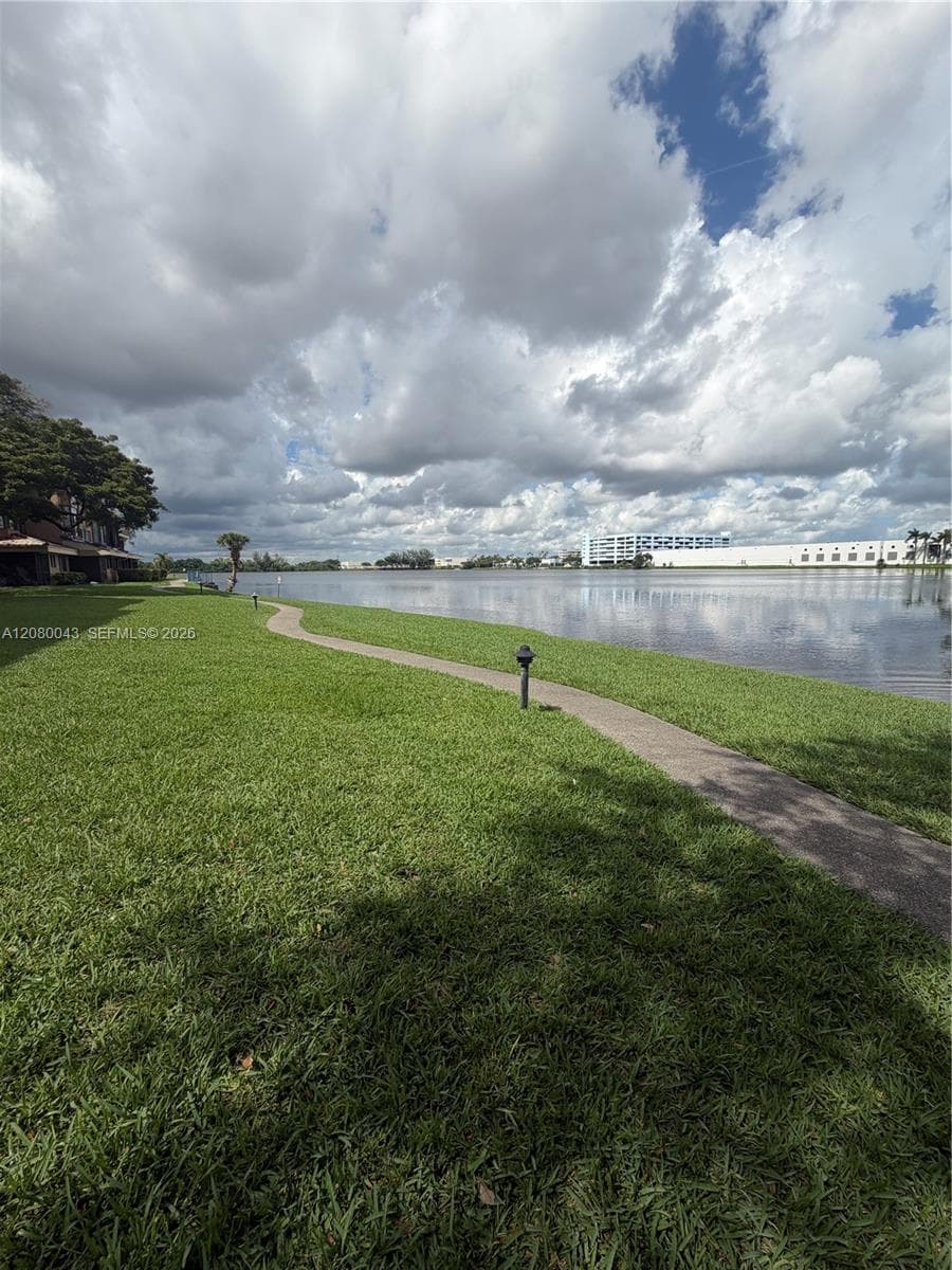 Large lake front with lit walking/jogging trail behind the unit.