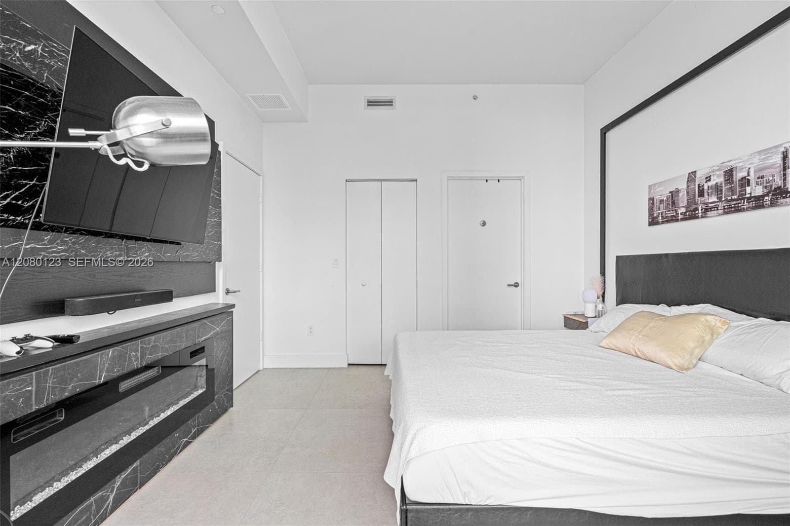 Spacious bedroom with king bed, designer skyline art, and abundant natural light at this Brickell penthouse.