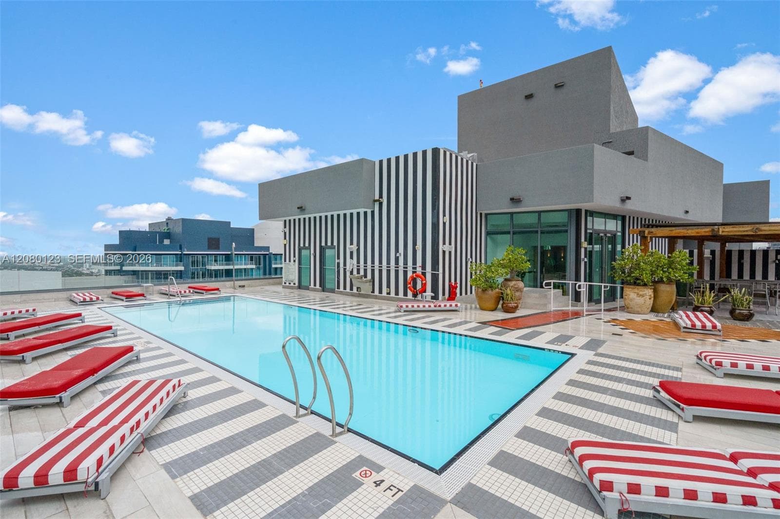 Resort-style pool with cabanas and signature SLS striped accents at SLS Brickell Dua.