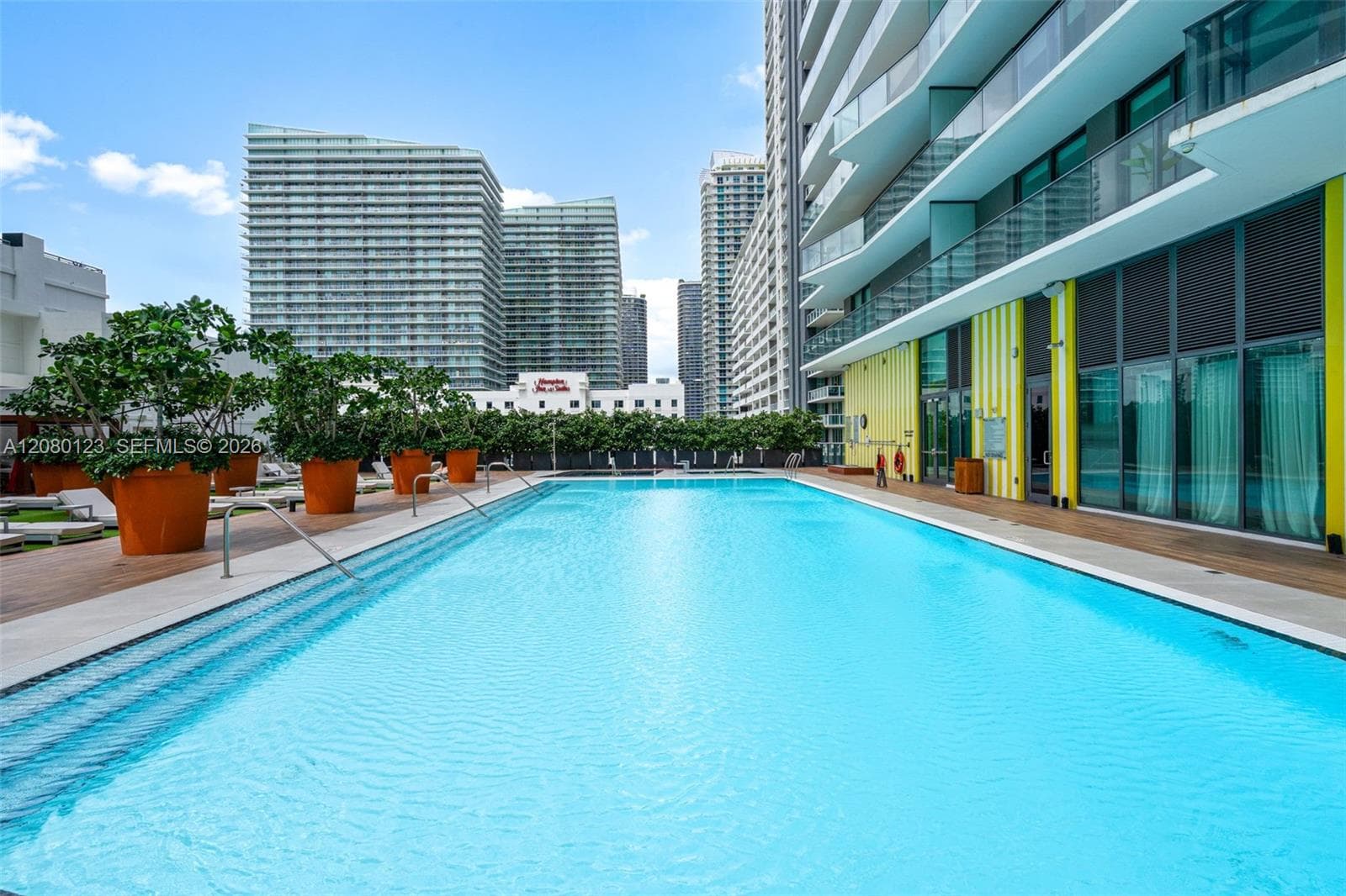 Resort-style pool deck with cabanas, sunbeds, and tropical landscaping at SLS Brickell Dua.