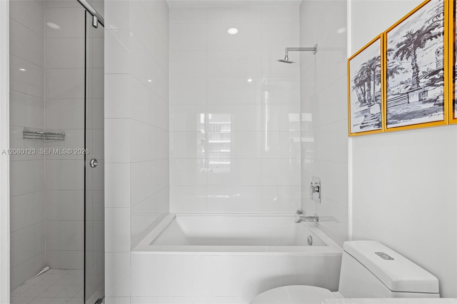 Spa-style primary bathroom with deep soaking tub, frameless glass walk-in shower, and marble-look porcelain finishes.