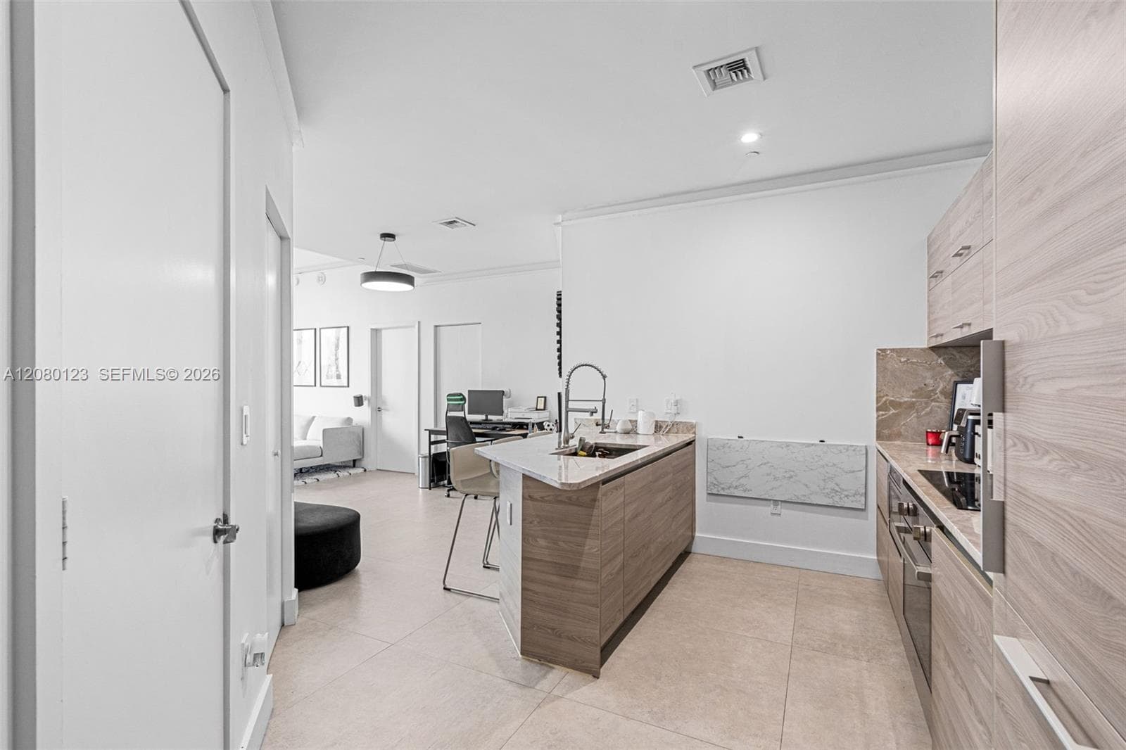 Sleek kitchen with stainless sink, marble counters, and integrated Bosch appliances.