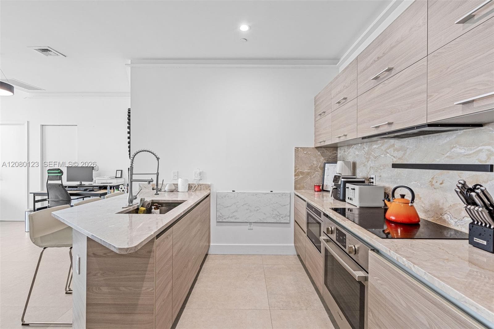 Gourmet kitchen with marble waterfall island, breakfast bar, and integrated Bosch appliances at PH-5209.