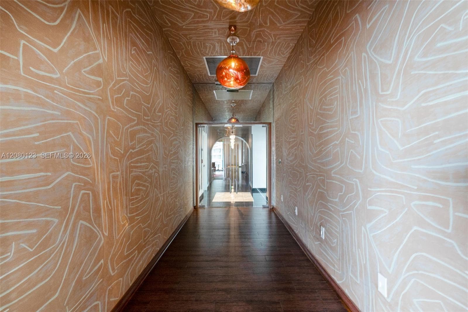 Boutique-style resident corridor with patterned wallcovering at SLS Brickell Dua.