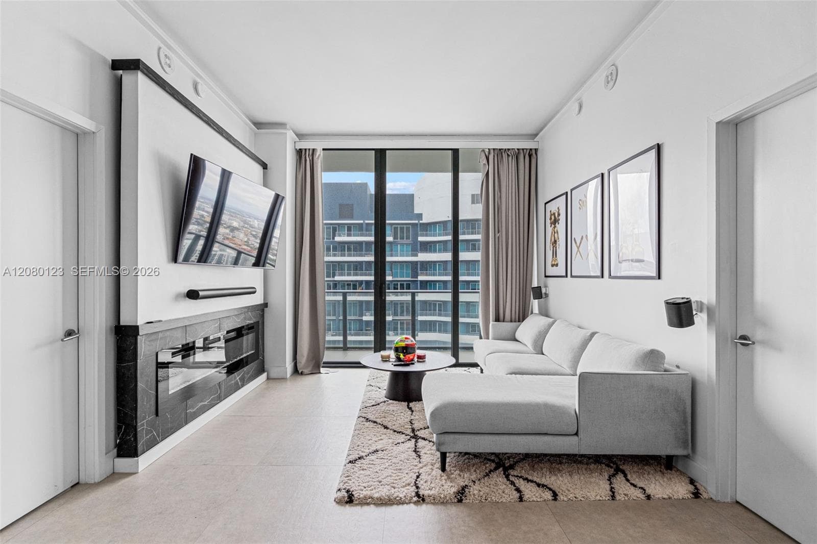 Open-concept great room at SLS Brickell Dua PH-5209 featuring designer art, oversized sectional, and seamless flow into the chef's kitchen on the 52nd floor.
