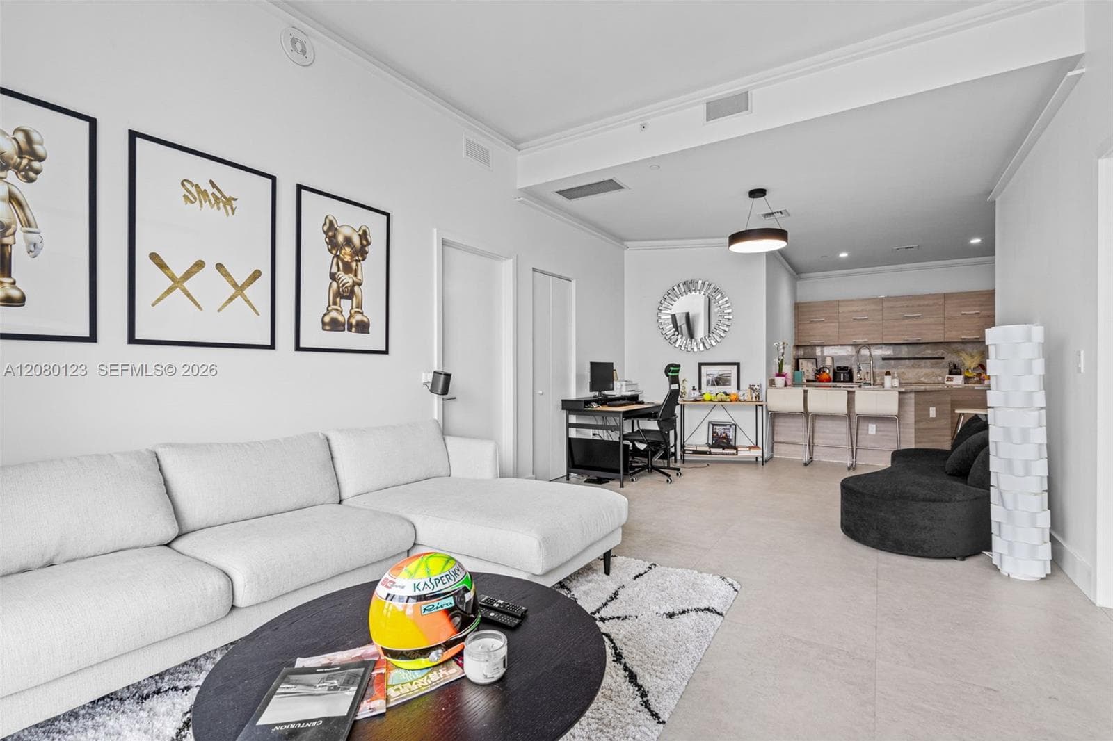 Designer-curated living room featuring custom KAWS art, marble accents, and open flow into the gourmet kitchen at PH-5209.