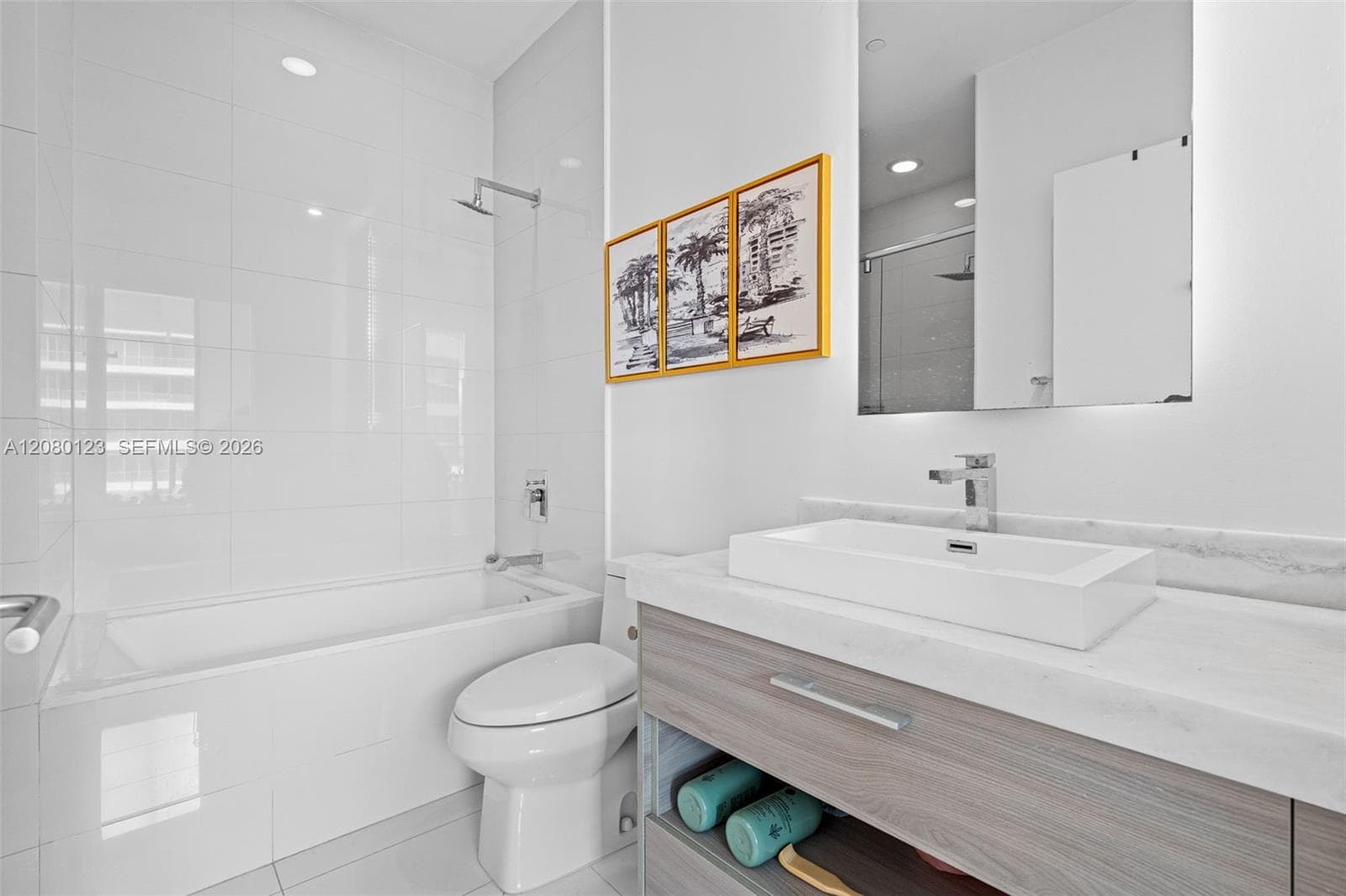 Spa-style bathroom with deep soaking tub and walk-in shower - finished in oversized white tile at SLS Brickell Dua.