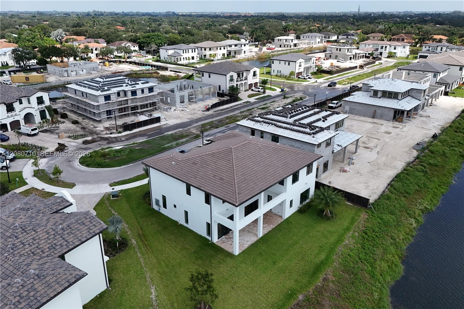 Two-story residence with a brown tile roof and white exterior