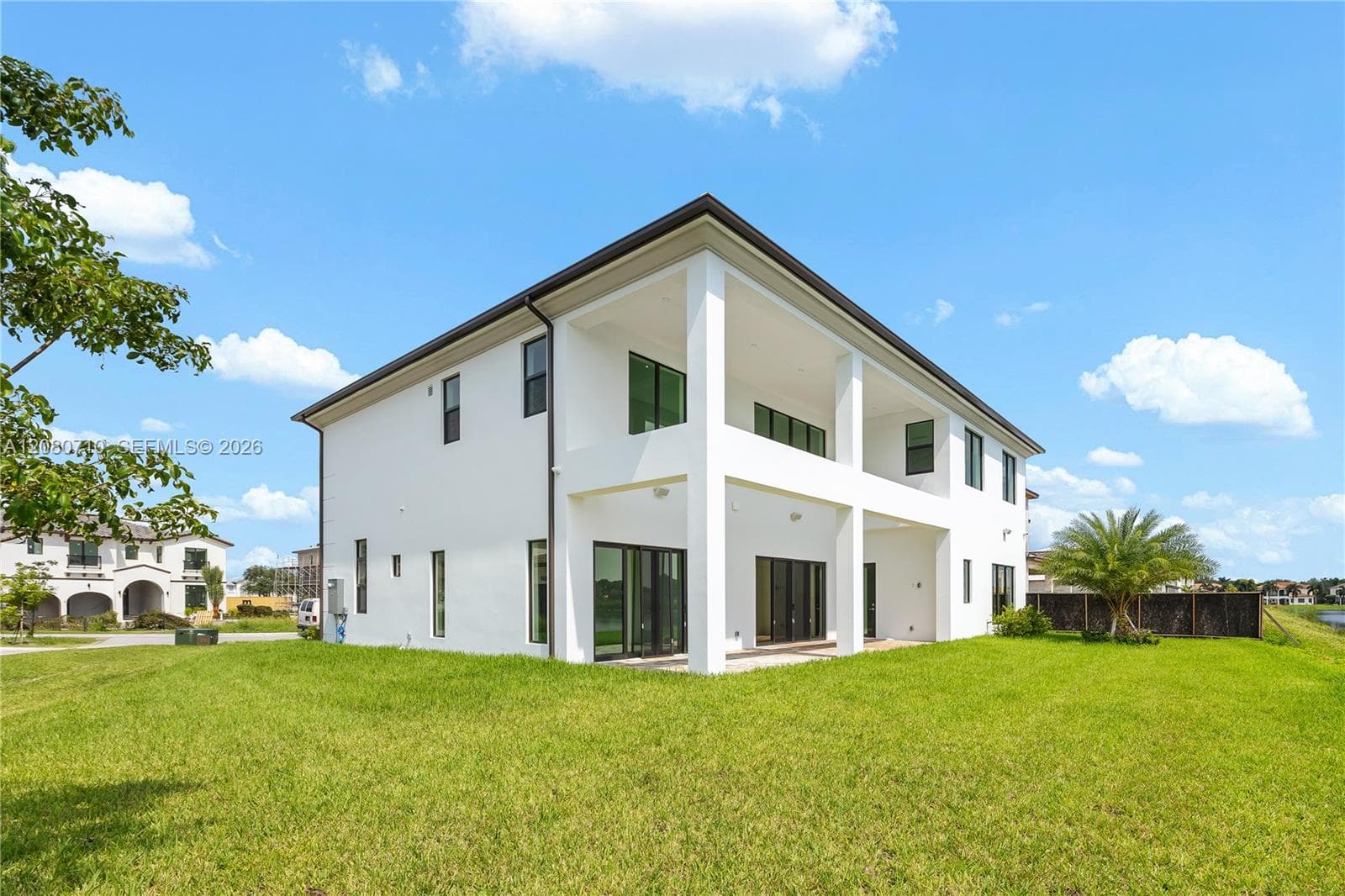 Two-story exterior with white stucco finish, black-framed windows, and a black roof
