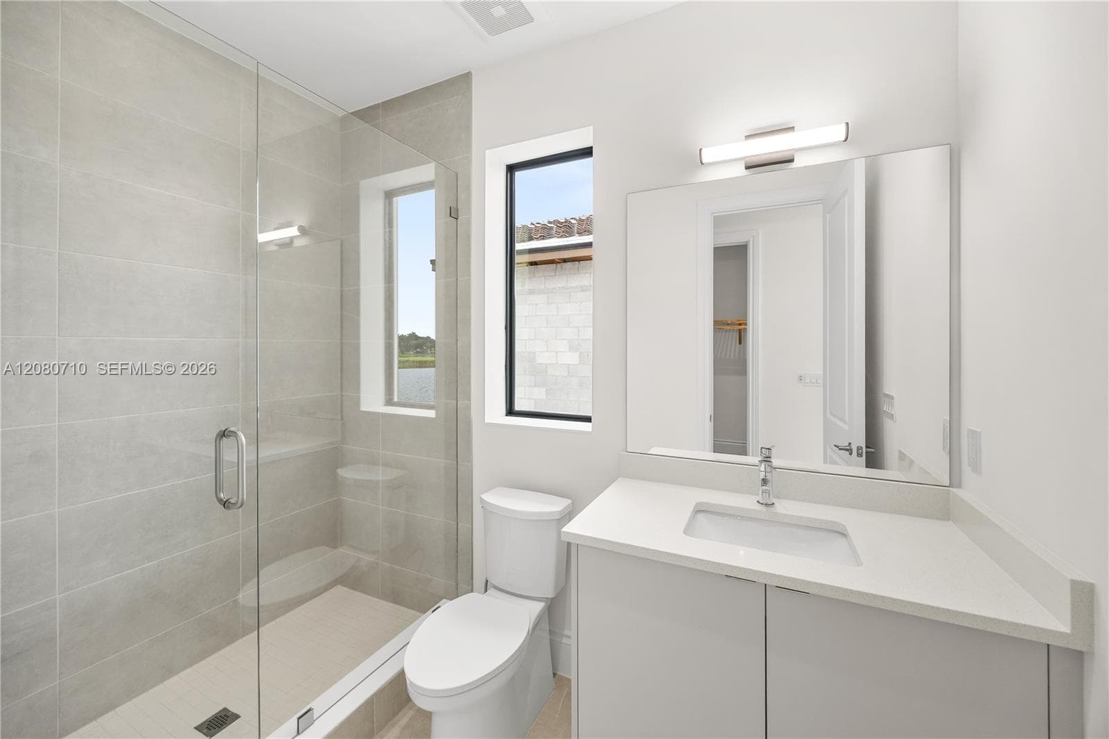 Glass-enclosed shower with a built-in bench