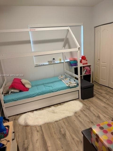 Wood-finish flooring with neutral wall paint and white bi-fold closet doors