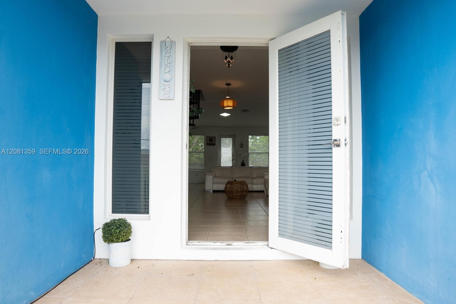 Entrance featuring a white door with horizontal glass inserts, a vertical sidelight window, and tile flooring