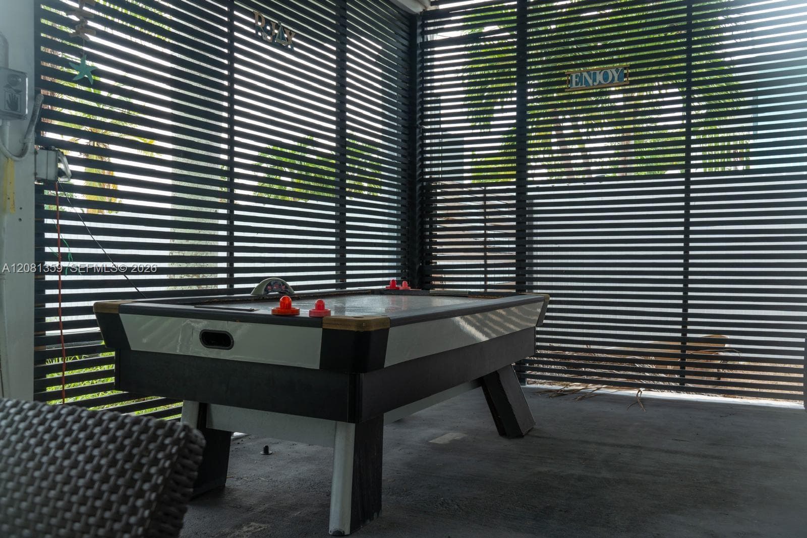 Enclosed patio featuring slatted privacy screening and concrete flooring