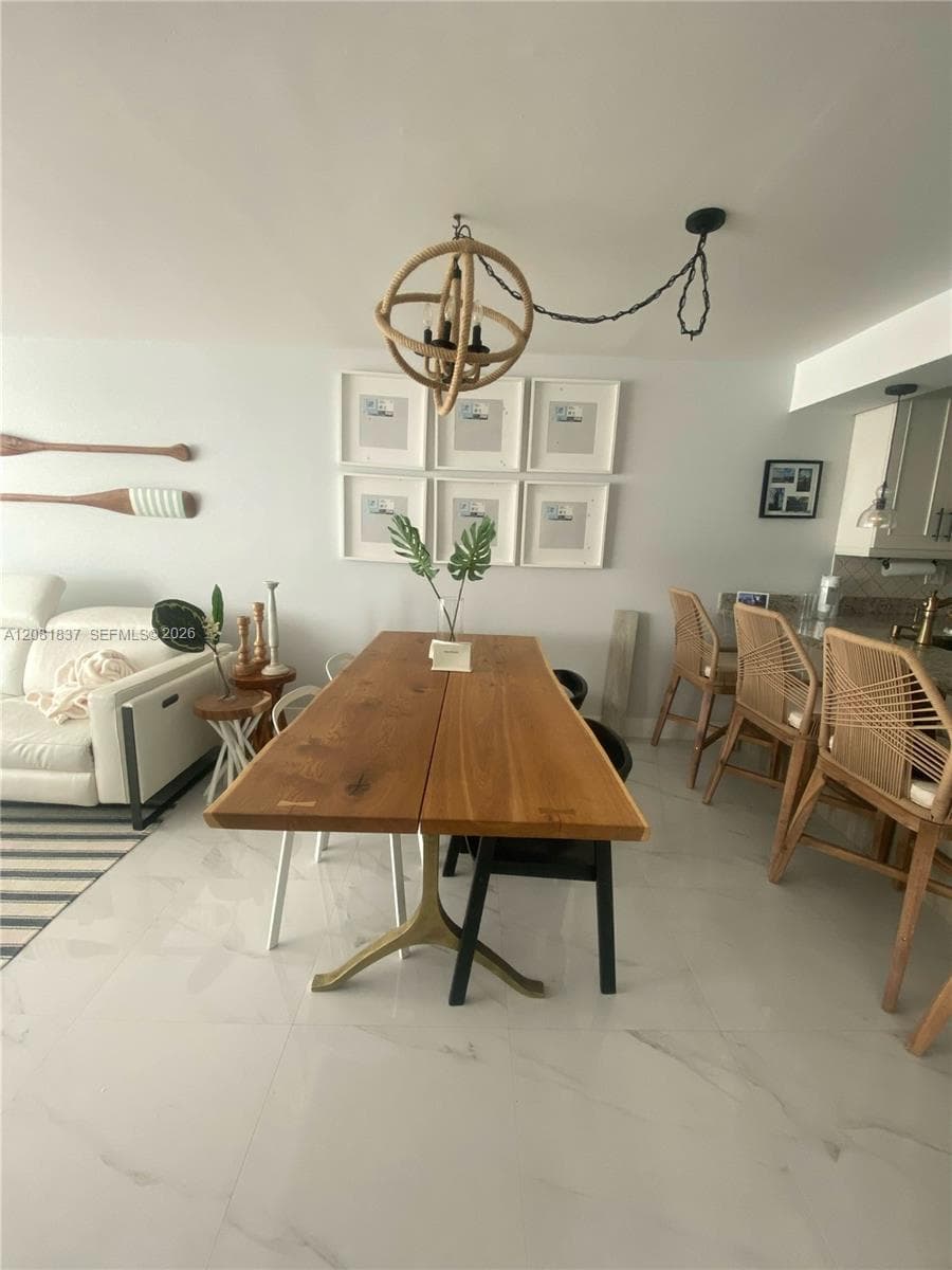 Large-format tile flooring, sphere-style chandelier with natural rope detailing, and neutral interior finishes