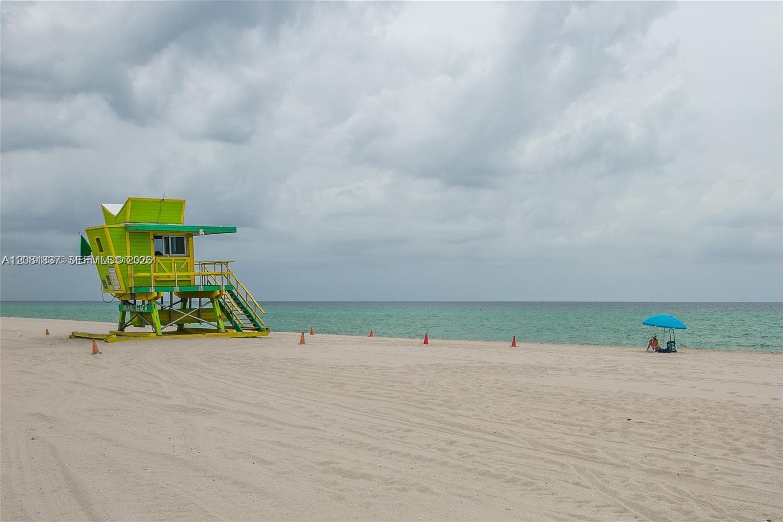 Sandy beach shoreline featuring ocean water and a structure